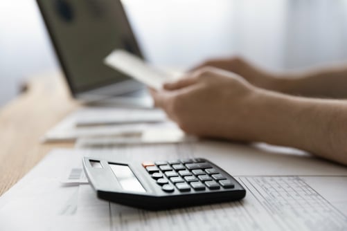 Man sat at a desk using a calculator