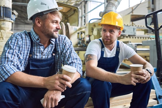 Two builders talking over coffee