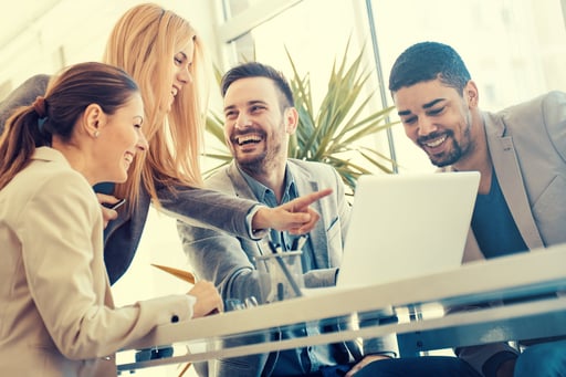 Work colleagues laughing and looking at laptop