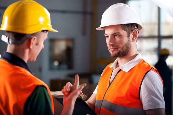 two colleagues wearing hi-vis vests and hard hats