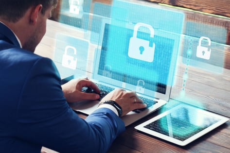 Cybercriminal hacker attempting to break through cyber defences on his laptop and tablet