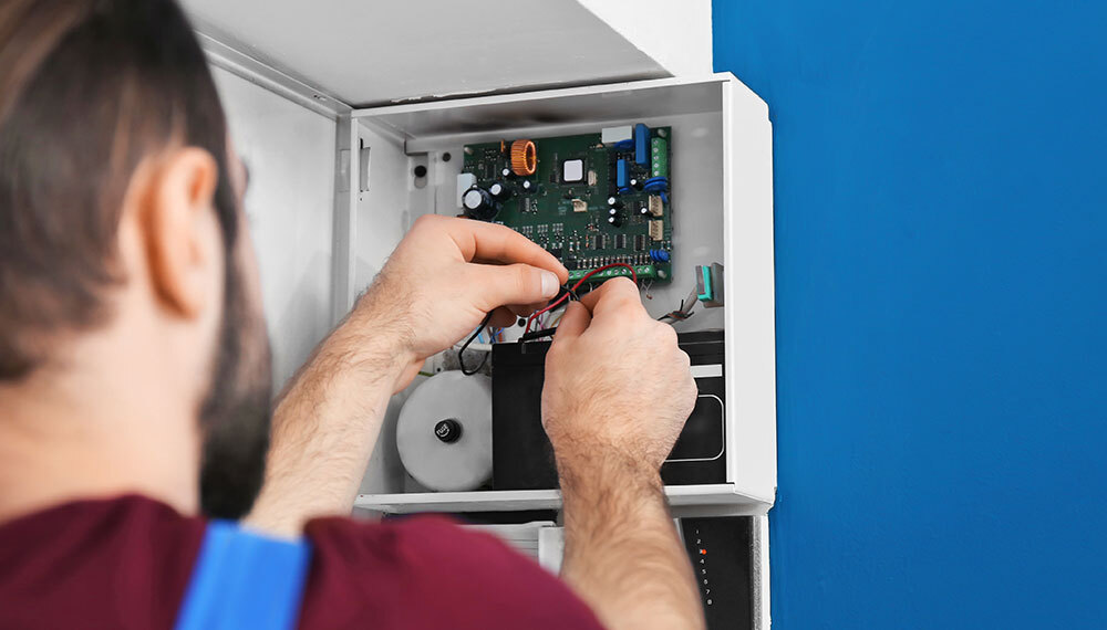 Vigil Fire & Security engineer repairing security alarm